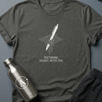Through the Floor sci-fi t-shirt — a pen falling through a glitching grid where the collision mesh failed — Dark Heather unisex tee — Apsion Outpost