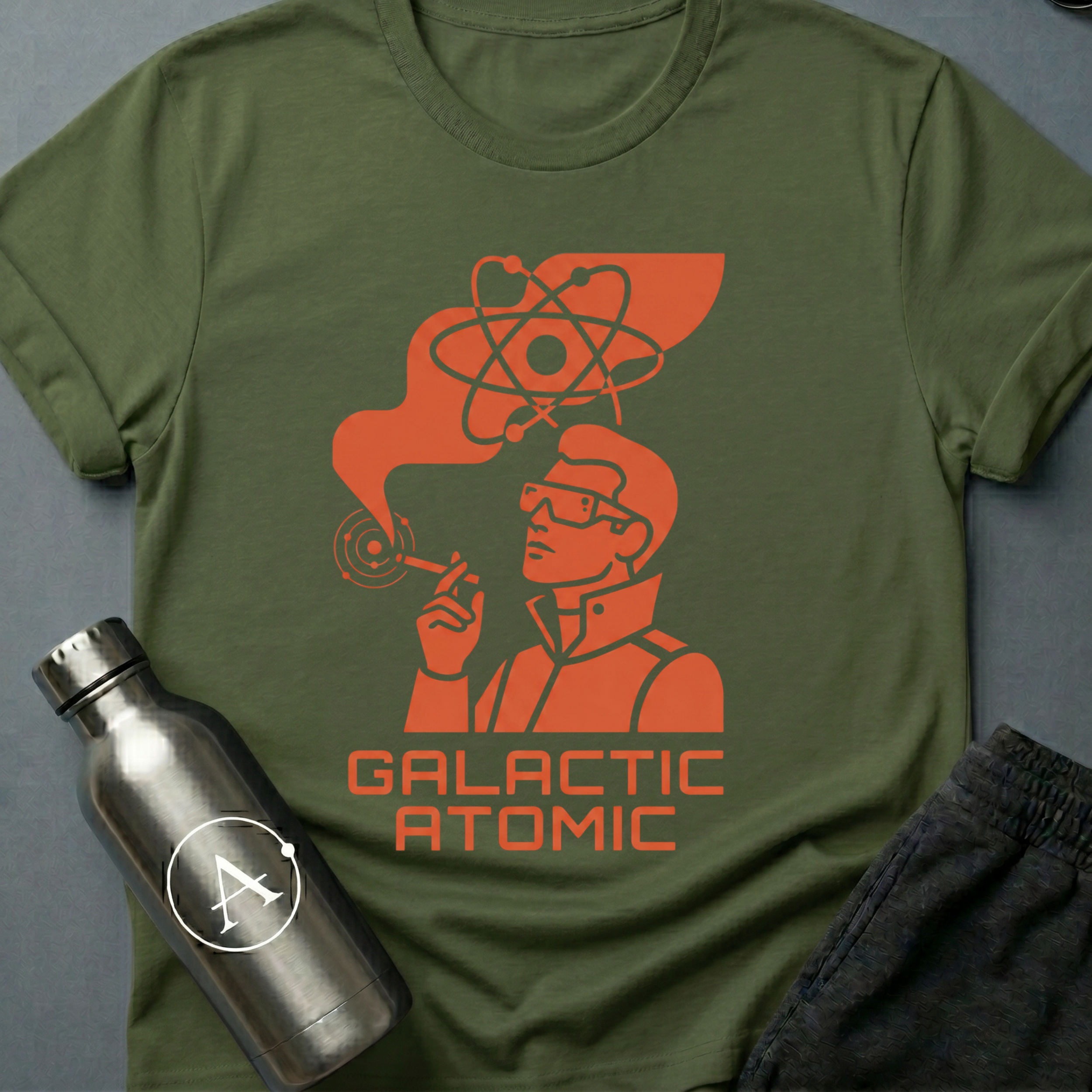 Apsion Outpost graphic t-shirt 'Trusted Since the Empire' in Military Green — atomic-age mascot in dressing gown with sunglasses, smoking under an atom symbol. On-shirt text reads GALACTIC ATOMIC.