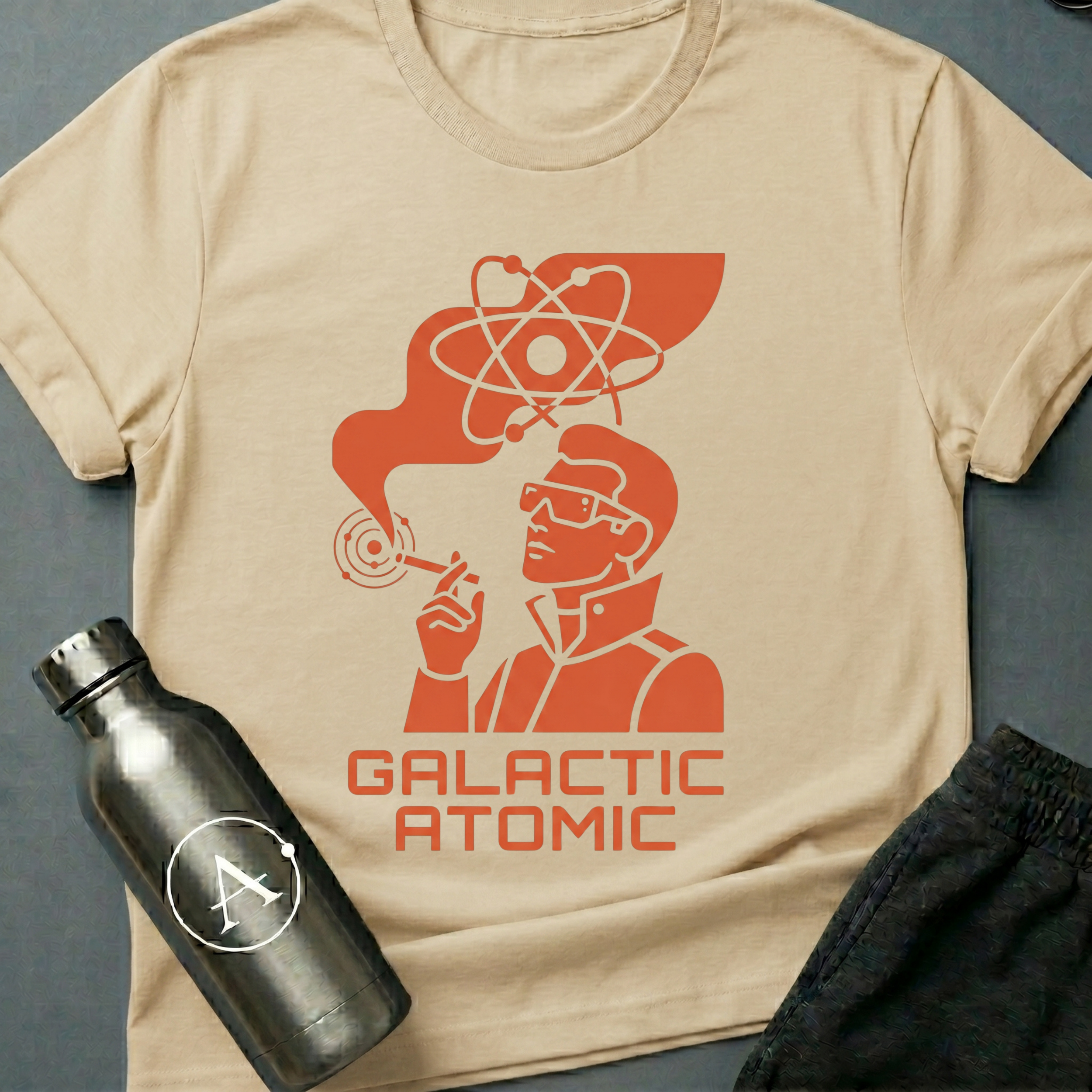 Apsion Outpost graphic t-shirt 'Trusted Since the Empire' in Natural — atomic-age mascot in dressing gown with sunglasses, smoking under an atom symbol. On-shirt text reads GALACTIC ATOMIC.